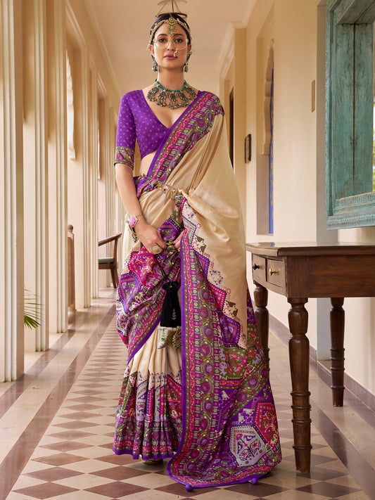 Woman wearing beige silk blend saree with traditional indian motif work and violet blouse