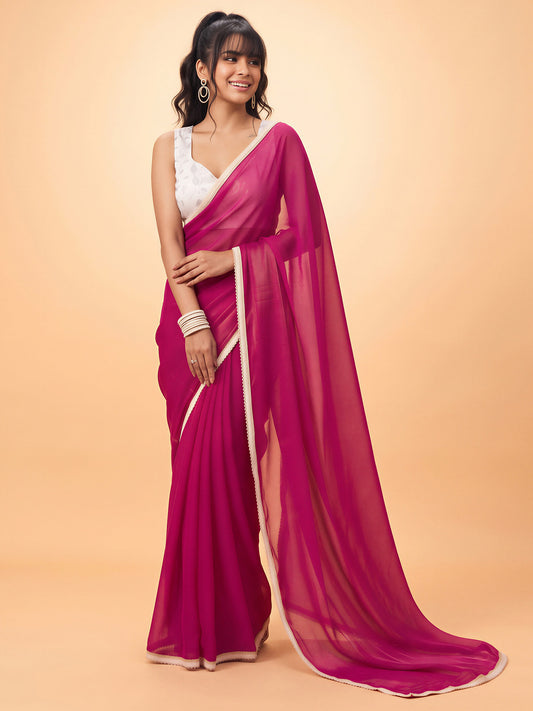Woman wearing pink satin silk saree with clean solid-tone finish and white blouse