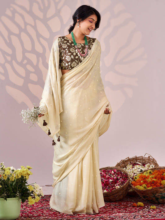 Woman wearing cream chiffon saree with ornamented surface design and olive blouse