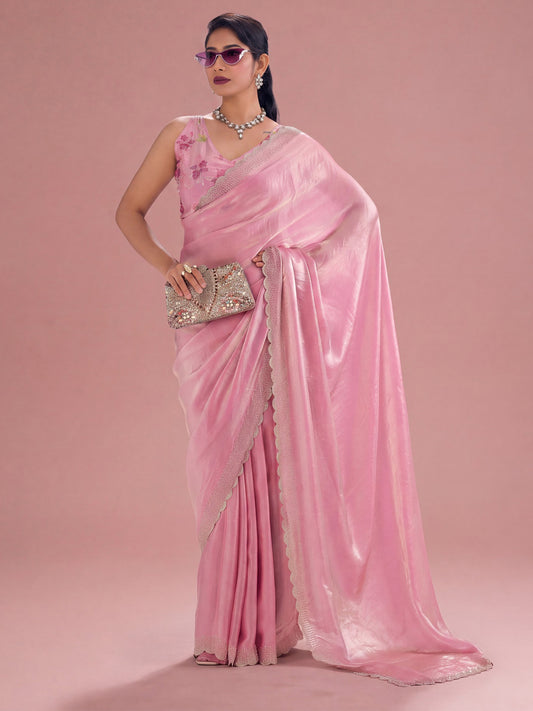 Woman wearing pink silk saree with ornamented surface design and pink blouse