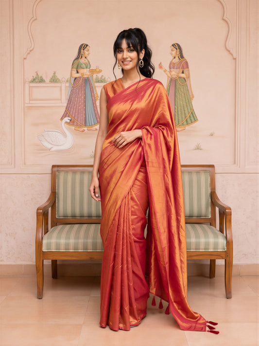 Woman wearing orange vichitra silk saree with clean solid-tone finish and orange blouse
