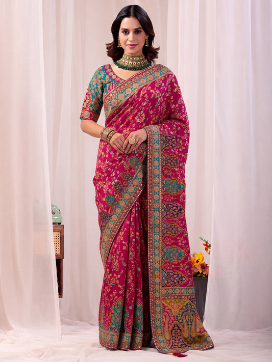 Woman wearing pink silk blend saree with traditional indian motif work and aqua blue blouse