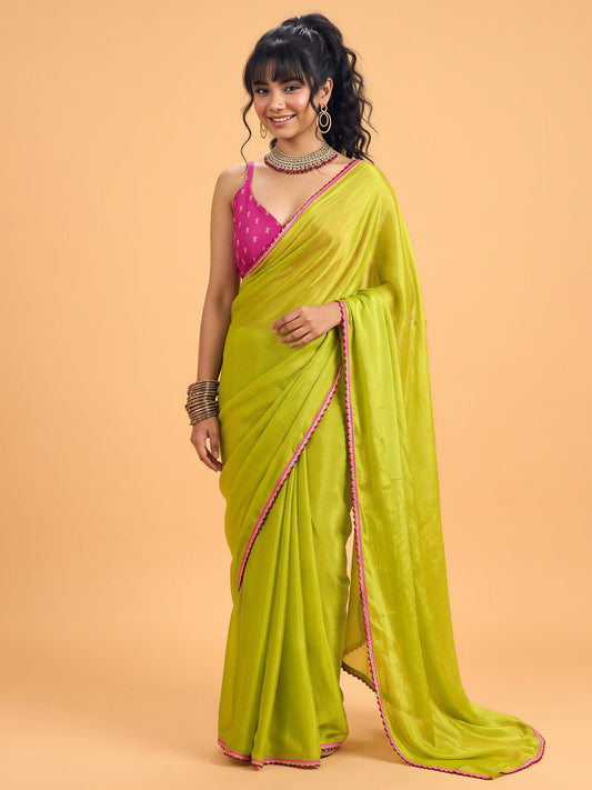 Woman wearing olive silk saree with clean solid-tone finish and magenta blouse