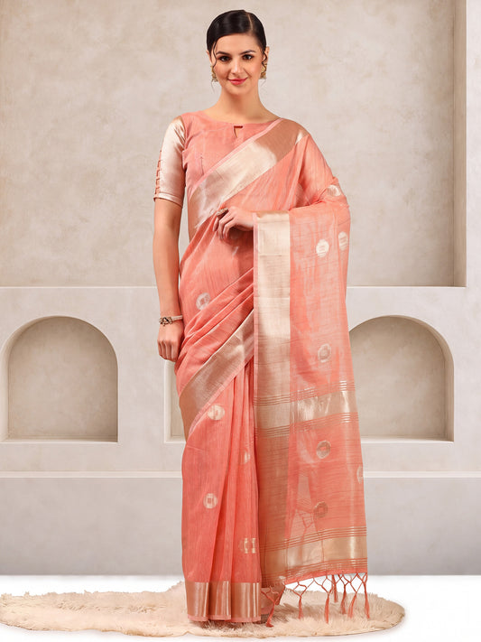 Woman wearing peach linen saree with zari butta (metallic motif) work and peach blouse