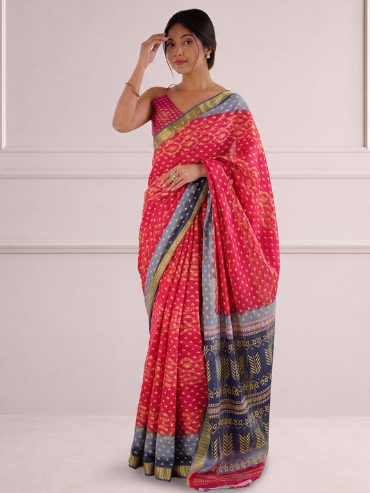 Woman wearing pink cotton saree with bandhani tie-dye dot work and pink blouse