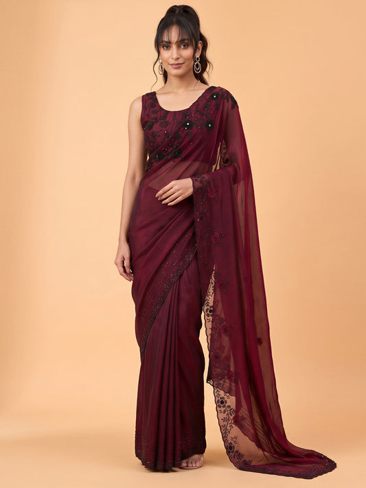 Woman wearing maroon satin silk saree with clean solid-tone finish and maroon blouse
