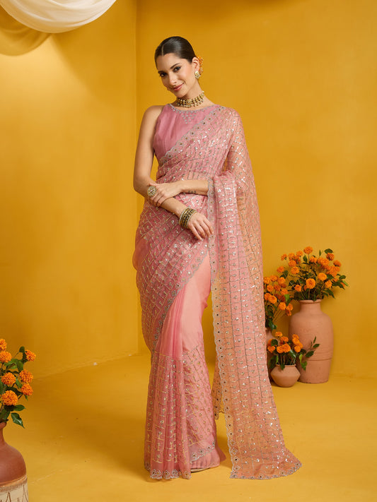 Woman wearing pink soft silk saree with ornamented surface design and pink blouse
