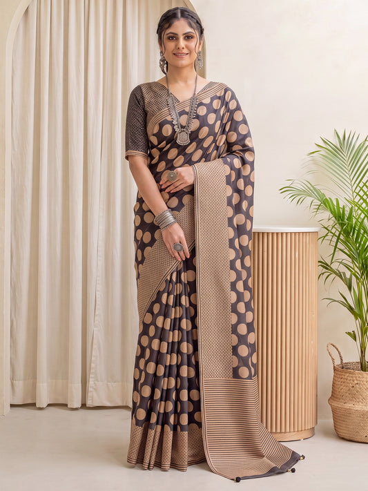 Woman wearing black silk blend saree with polka dot pattern and tan blouse