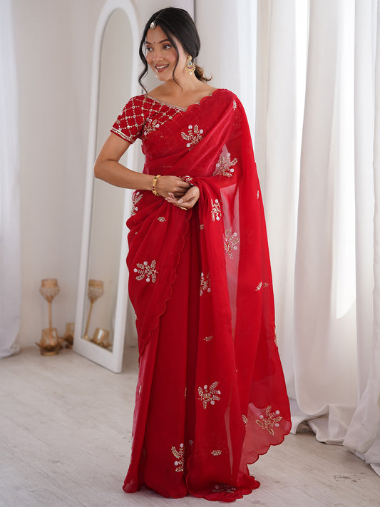 Woman wearing red satin saree with ornamented surface design and red blouse
