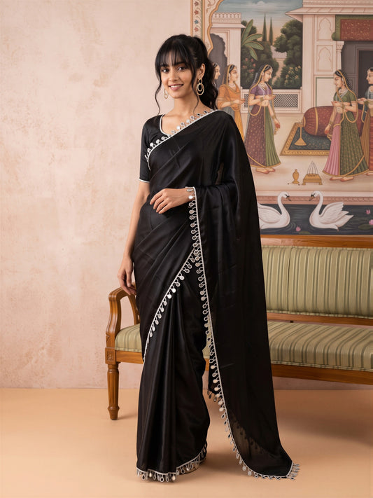 Woman wearing black satin saree with clean solid-tone finish and black blouse