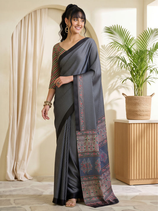 Woman wearing charcoal grey satin saree with polka dot pattern and multicolored blouse