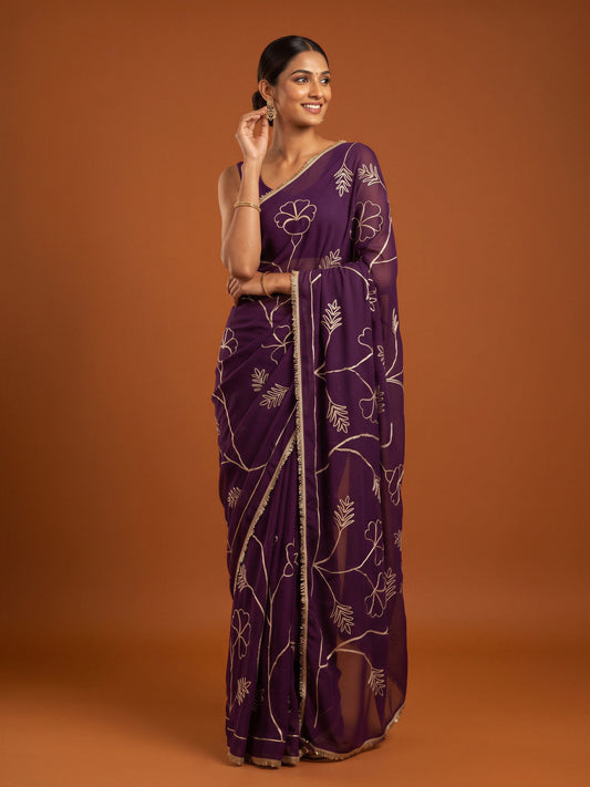 Woman wearing purple georgette saree with embroidered motif work and purple blouse