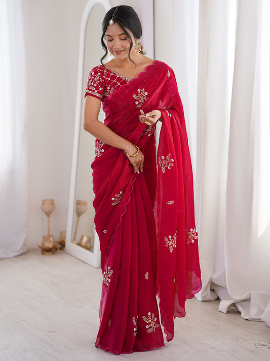 Woman wearing pink satin saree with ornamented surface design and pink blouse
