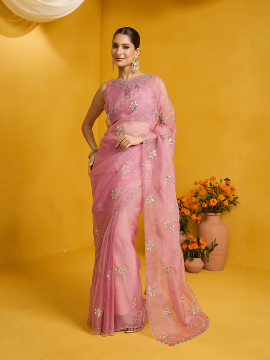 Woman wearing pink pure georgette saree with ornamented surface design and pink blouse