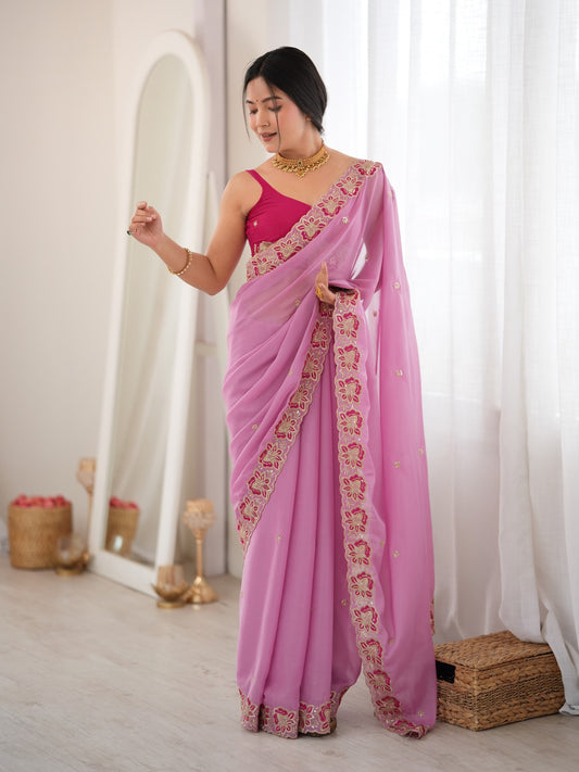 Woman wearing pink georgette saree with ornamented surface design and pink blouse