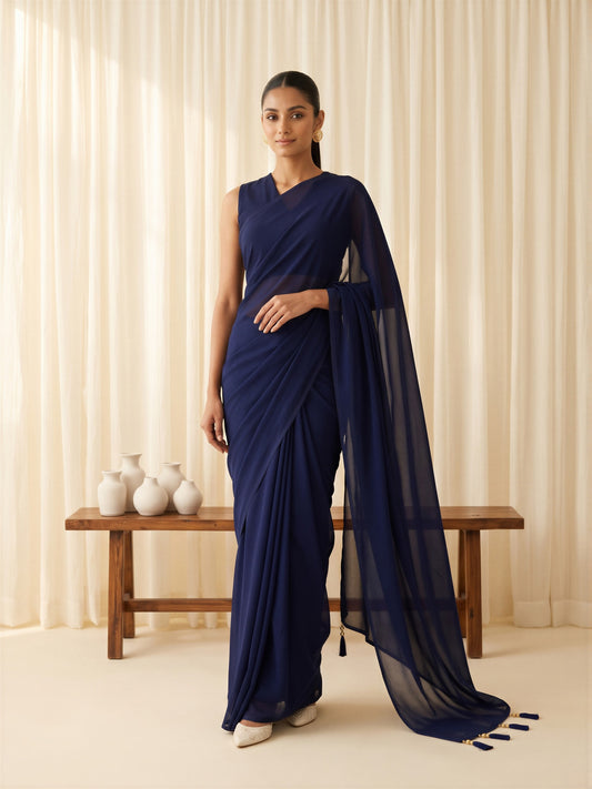 Woman wearing navy blue georgette saree with clean solid-tone finish and navy blue blouse