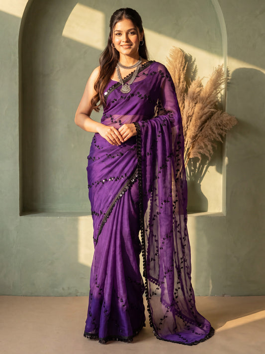 Woman wearing purple chiffon saree with ornamented surface design and purple blouse