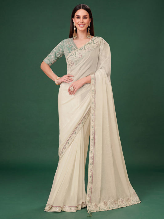 Woman wearing off white georgette saree with ornamented surface design and turquoise blouse