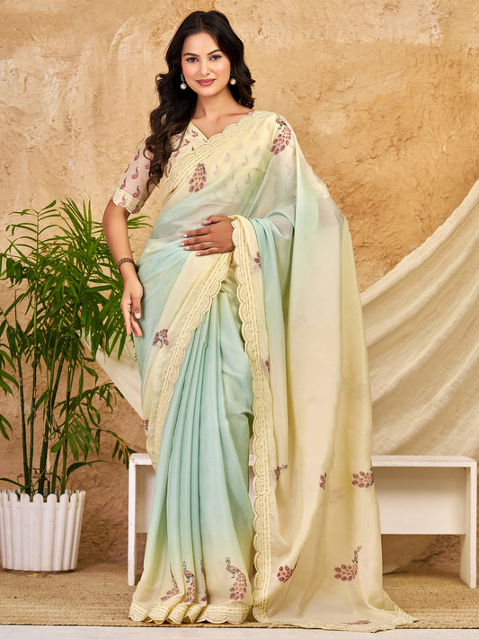 Woman wearing mint green georgette saree with peacock motif design and mint green blouse