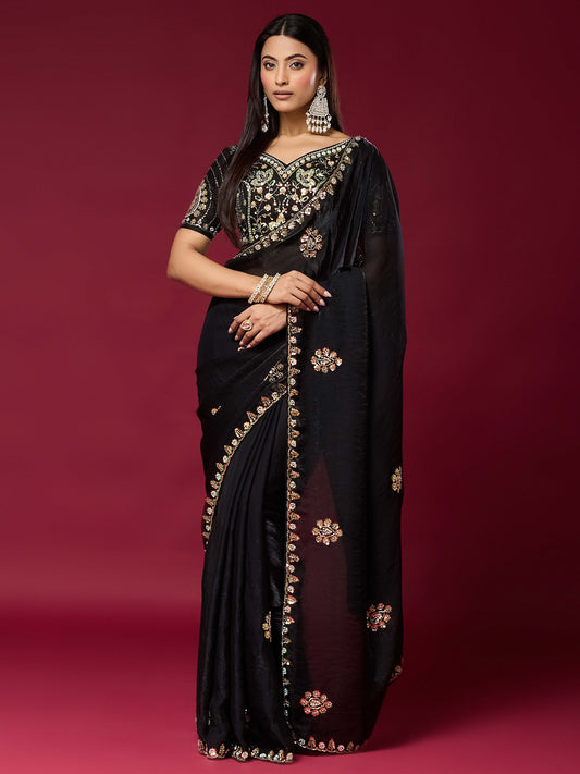 Woman wearing black satin silk saree with ornamented surface design and black blouse