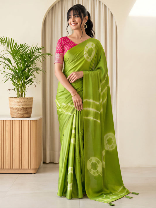 Woman wearing light green satin silk saree with tie-and-dye resist pattern and pink blouse