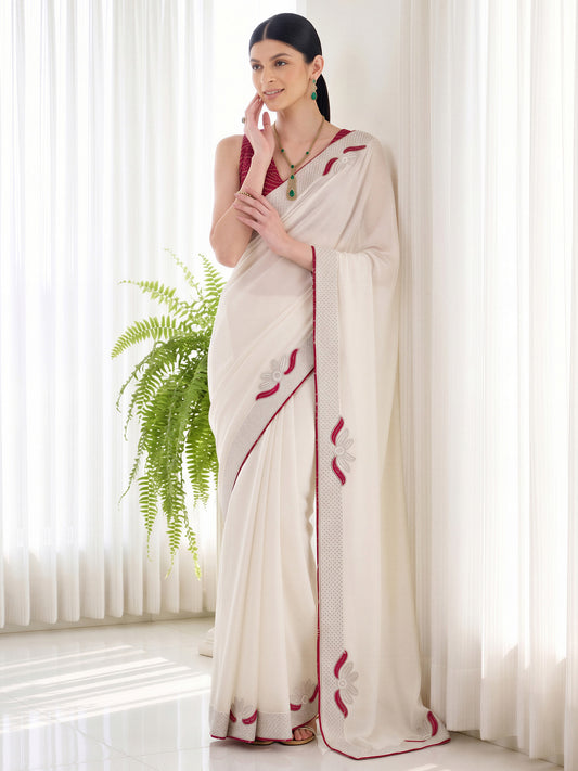 Woman wearing white vichitra silk saree with ornamented surface design and maroon blouse