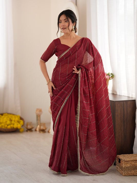 Woman wearing maroon georgette saree with ornamented surface design and maroon blouse