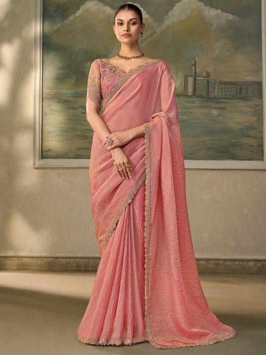 Woman wearing pink tissue saree with embroidered motif work and pink blouse