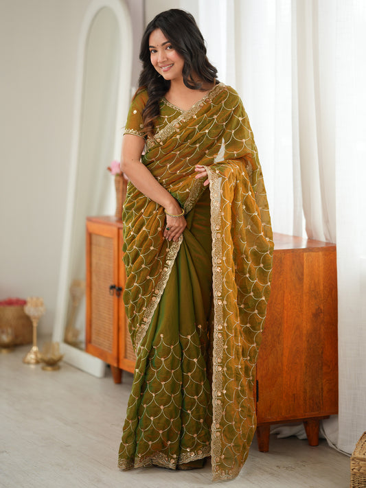 Woman wearing gold tissue saree with ornamented surface design and gold blouse
