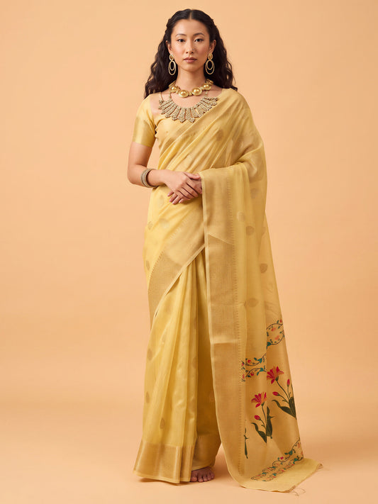 Woman wearing yellow tissue saree with zari butta (metallic motif) work and yellow blouse