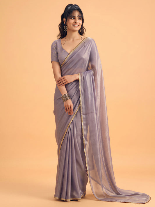 Woman wearing metallic silk saree with clean solid-tone finish and metallic blouse