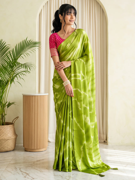Woman wearing light green satin silk saree with tie-and-dye resist pattern and pink blouse