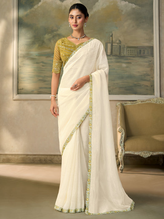Woman wearing white chiffon saree with embroidered motif work and gold blouse