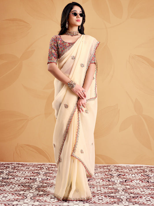 Woman wearing cream tissue saree with ornamented surface design and maroon blouse