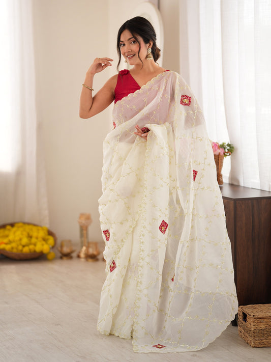 Woman wearing off white paper silk saree with ornamented surface design and pink blouse