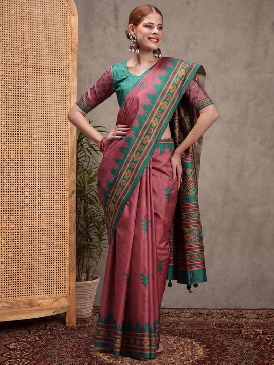 Woman wearing mauve silk blend saree with traditional indian motif work and teal green blouse