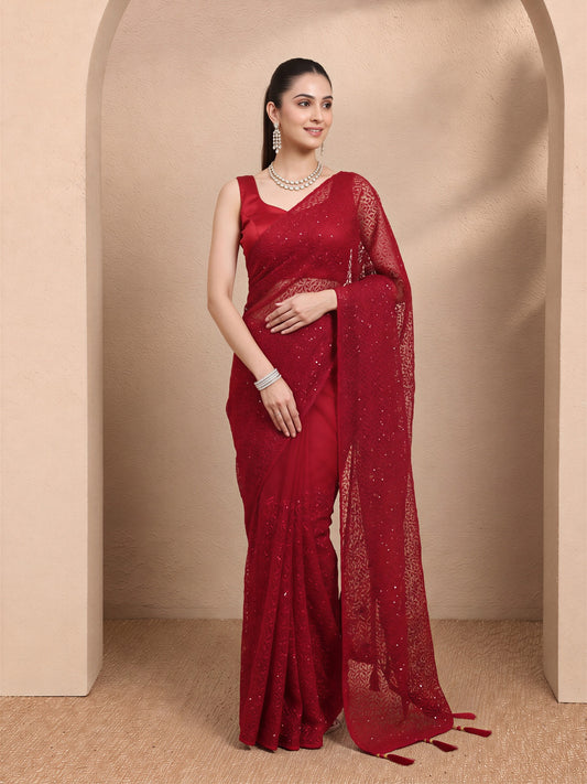 Woman wearing maroon net saree with embroidered motif work and maroon blouse