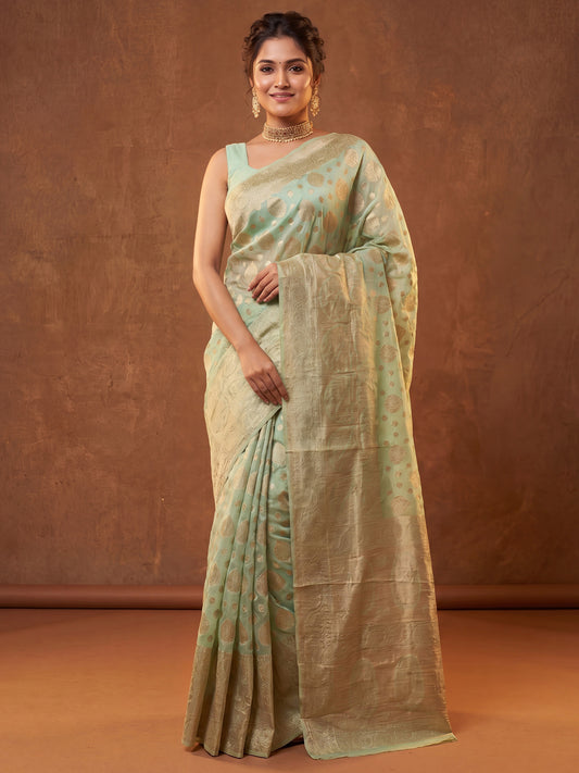 Woman wearing light green silk blend saree with zari butta (metallic motif) work and light green blouse