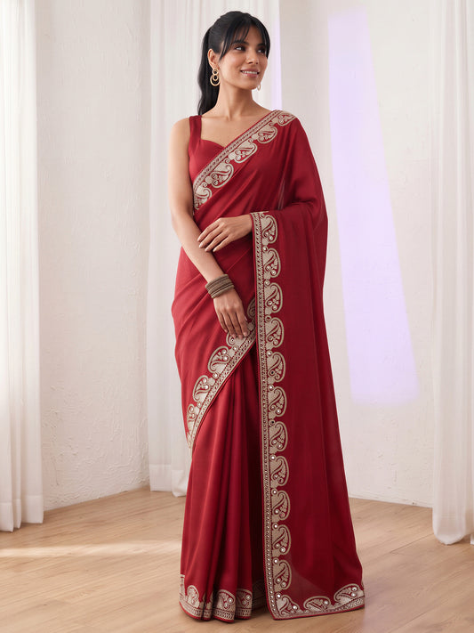 Woman wearing maroon vichitra silk saree with embroidered motif work and maroon blouse