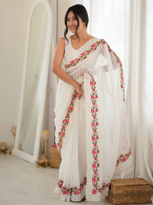 Woman wearing white georgette saree with ornamented surface design and white blouse