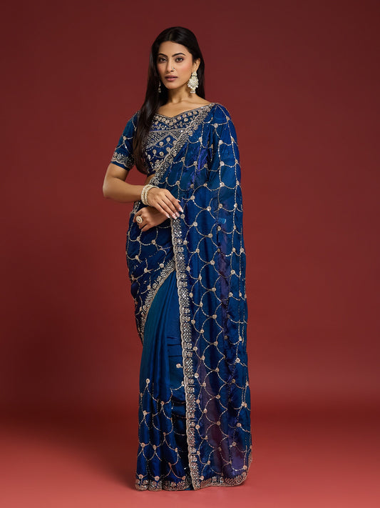 Woman wearing blue satin saree with ornamented surface design and blue blouse