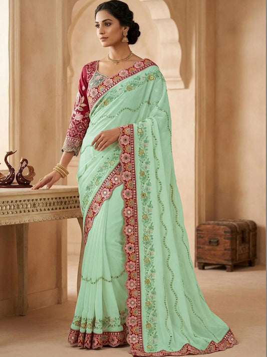 Woman wearing light green pure georgette saree with all-over floral design and pink blouse