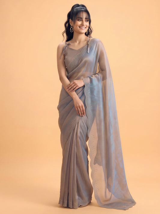 Woman wearing metallic satin silk saree with ornamented surface design and metallic blouse