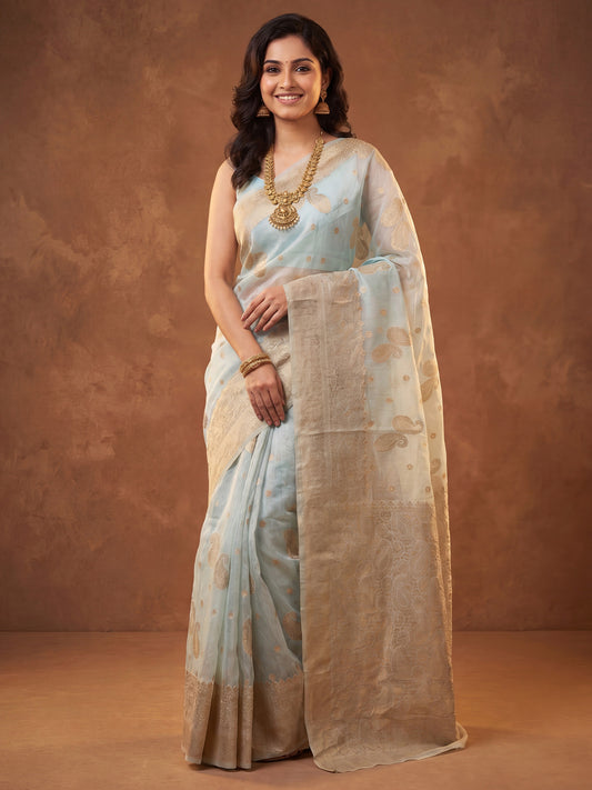 Woman wearing light blue silk blend saree with zari butta (metallic motif) work and light blue blouse