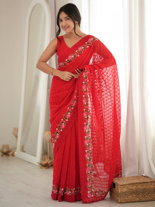 Woman wearing red georgette saree with ornamented surface design and red blouse