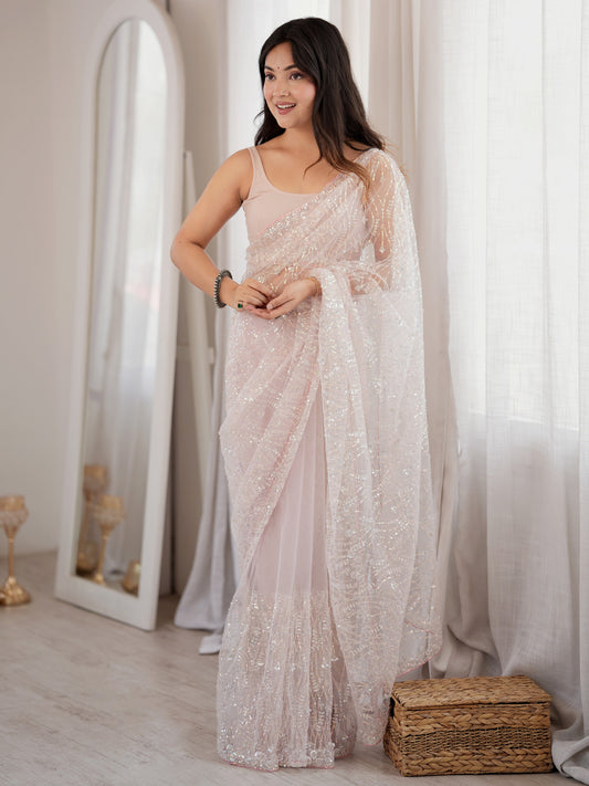 Woman wearing pink net saree with ornamented surface design and pink blouse