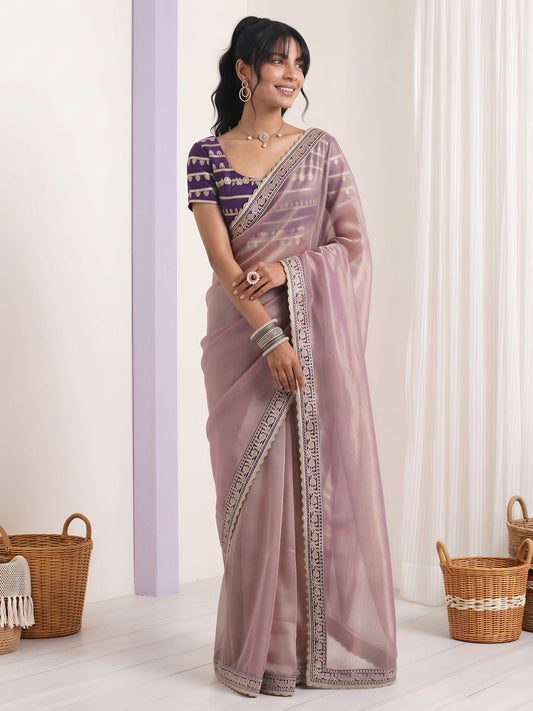 Woman wearing lavender net saree with embroidered motif work and purple blouse