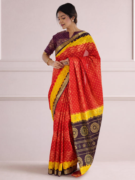 Woman wearing red cotton saree with bandhani tie-dye dot work and purple blouse