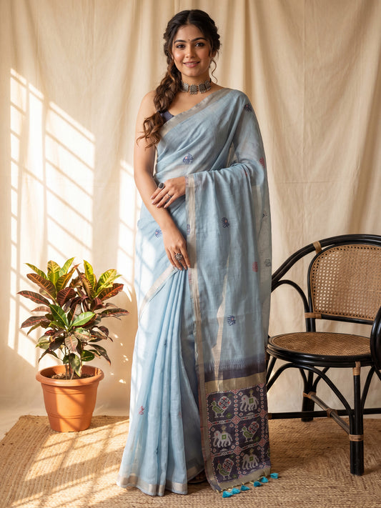 Woman wearing light blue cotton saree with ikat resist-dyed pattern and navy blue blouse