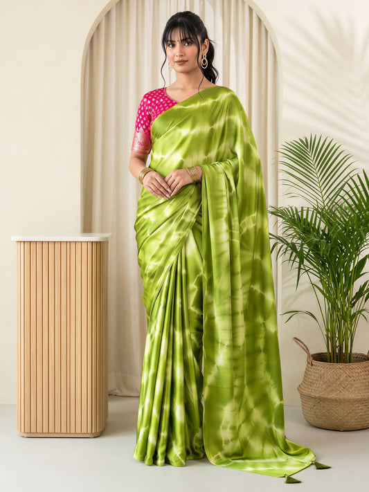 Woman wearing light green satin silk saree with tie-and-dye resist pattern and pink blouse